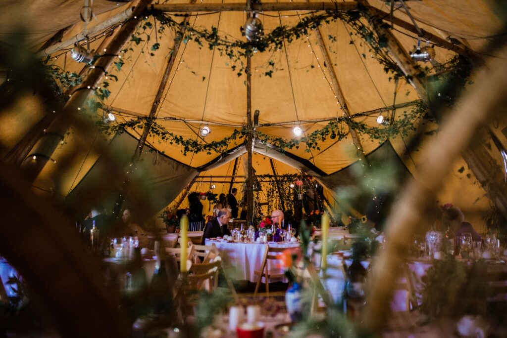 wood beams tipi with lights and flowers wedding